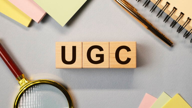 An intriguing image featuring the letters: UGC placed on round cubes on a table, symbolizing the concept of User-Generated Content. The image visually represents the focus on the value and impact of UGC for brands in the digital age